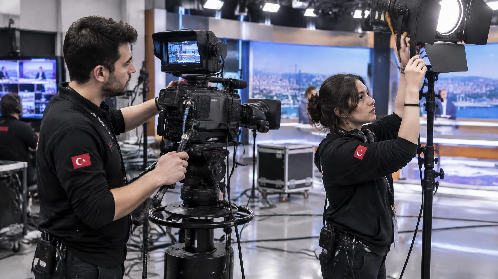 Technical crew adjusting camera equipment on a live TV set